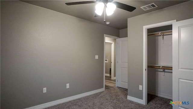 unfurnished bedroom featuring ceiling fan, dark carpet, and a closet