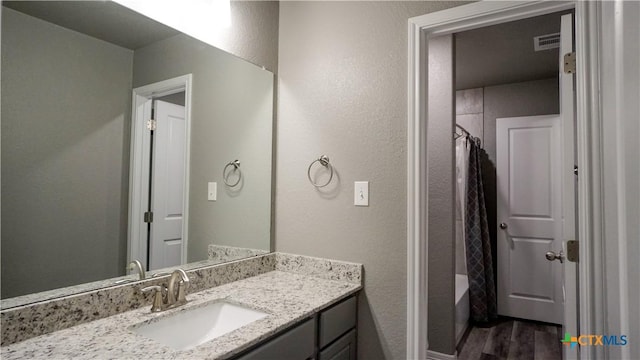 bathroom featuring vanity, hardwood / wood-style flooring, and shower / bathtub combination with curtain