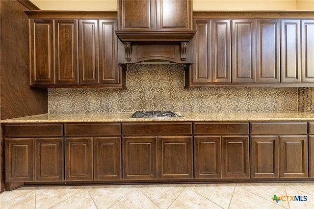 26815 Tulip Mdw, Boerne, TX 78015 - kitchen featuring stainless steel gas cooktop, light tile patterned floors, dark brown cabinetry, and decorative backsplash
