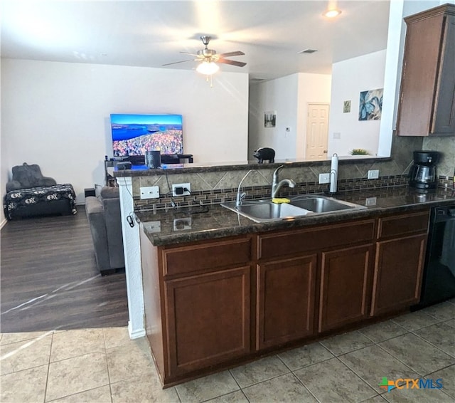 kitchen with black dishwasher, kitchen peninsula, sink, ceiling fan, and backsplash