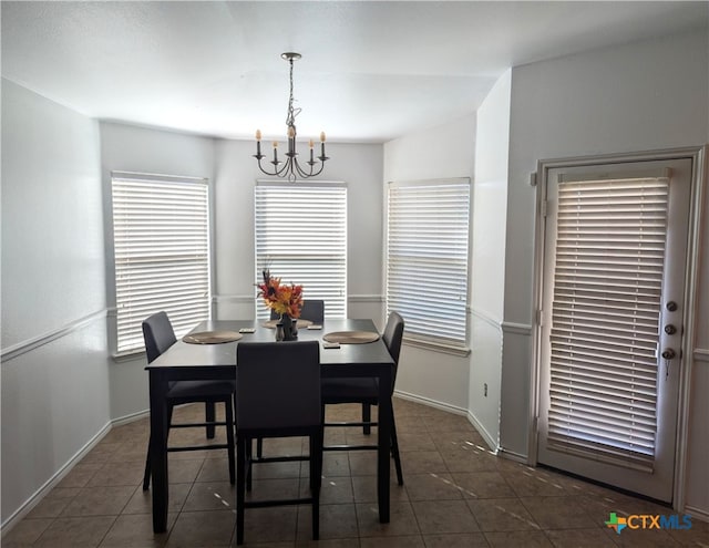 tiled dining space featuring an inviting chandelier