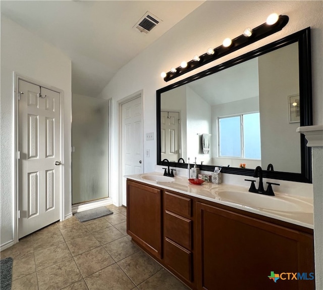 bathroom with vanity, a shower with door, tile patterned floors, and vaulted ceiling