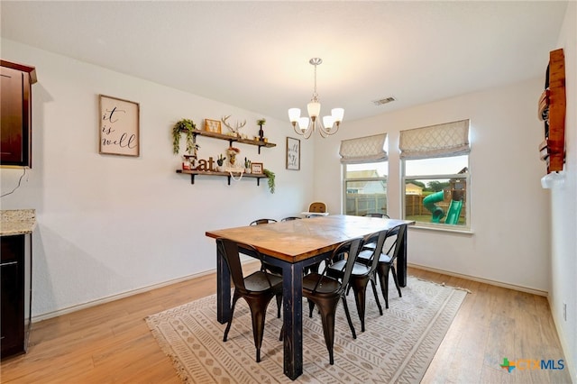 dining room featuring light hardwood / wood-style floors and an inviting chandelier