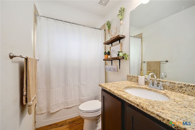 full bathroom featuring wood-type flooring, vanity, shower / bath combo, and toilet