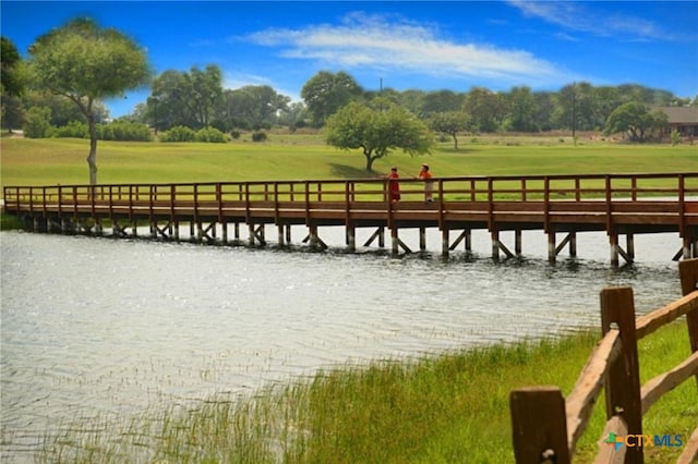 dock area with a water view and a lawn