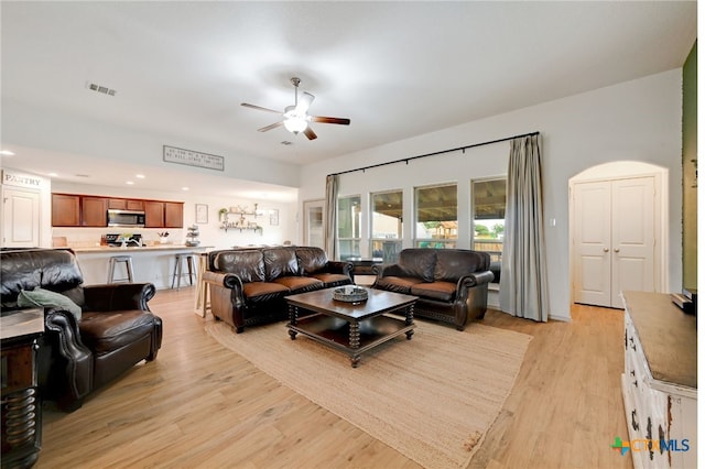 living room with light wood-type flooring and ceiling fan