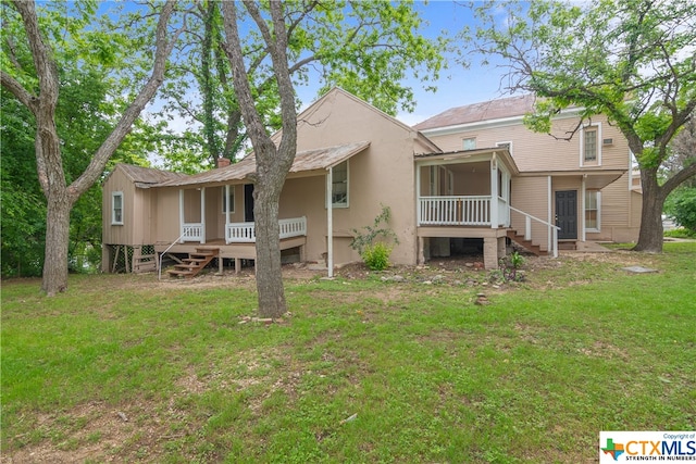 back of property featuring a sunroom and a yard