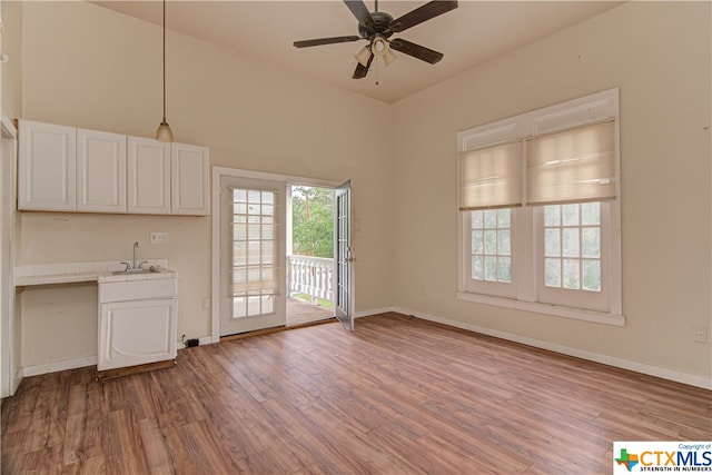 kitchen with light hardwood / wood-style floors, ceiling fan, and sink