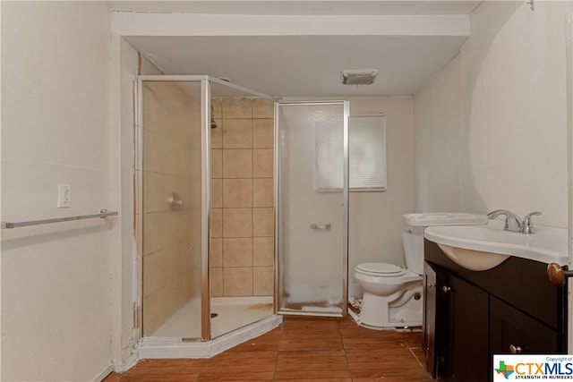 bathroom featuring wood-type flooring, vanity, toilet, and an enclosed shower