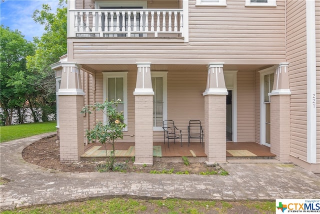 exterior space with a porch and a balcony