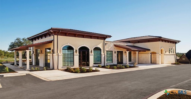 mediterranean / spanish-style house featuring driveway, an attached garage, and stucco siding