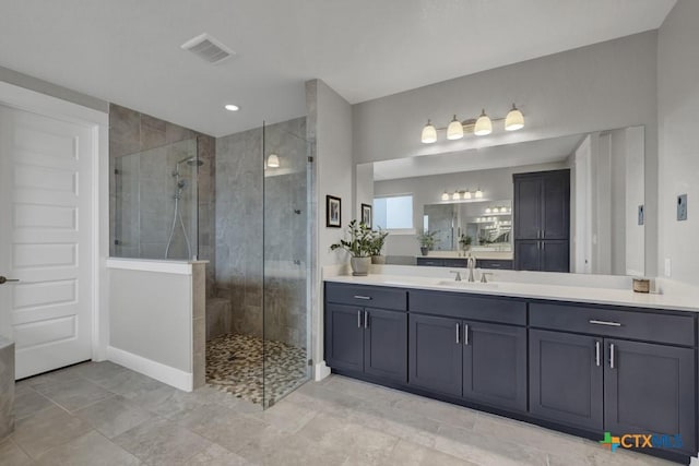 full bathroom with visible vents, walk in shower, and vanity