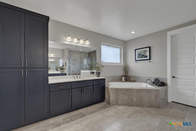 bathroom with a shower stall, a bath, and vanity