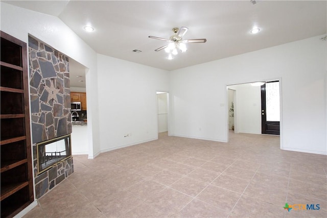 2216 Smith Bluff Rd, Salado, TX 76571 - unfurnished room with a ceiling fan, light tile patterned floors, a stone fireplace, recessed lighting, and baseboards