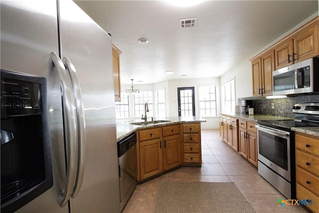 2216 Smith Bluff Rd, Salado, TX 76571 - kitchen featuring stainless steel appliances, a sink, backsplash, light tile patterned floors, and light stone countertops