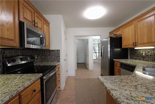 2216 Smith Bluff Rd, Salado, TX 76571 - kitchen featuring appliances with stainless steel finishes, light tile patterned floors, light stone countertops, and backsplash
