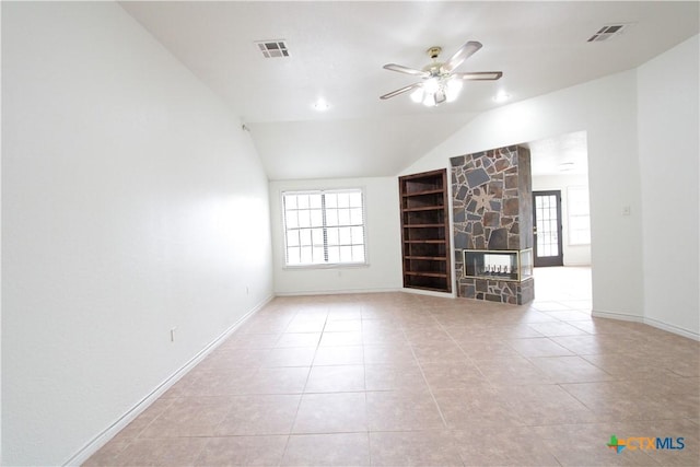 2216 Smith Bluff Rd, Salado, TX 76571 - unfurnished living room featuring a ceiling fan, built in shelves, lofted ceiling, a stone fireplace, and tile patterned floors