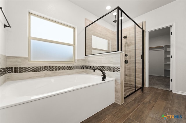 bathroom with shower with separate bathtub and hardwood / wood-style flooring