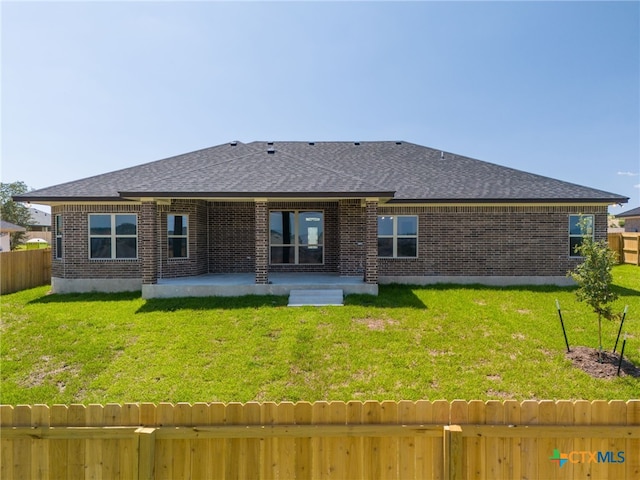 back of house with a patio and a yard