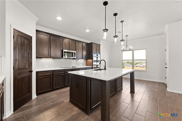 kitchen featuring stainless steel appliances, an inviting chandelier, an island with sink, a kitchen breakfast bar, and decorative light fixtures