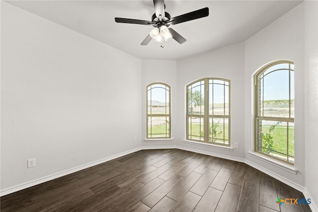 spare room featuring dark wood-type flooring and ceiling fan