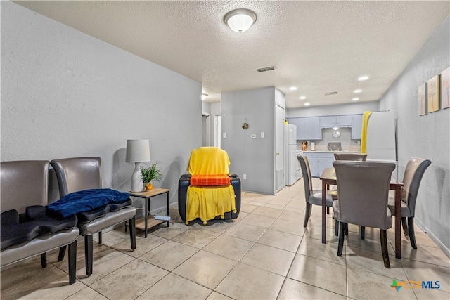 tiled dining space featuring a textured ceiling