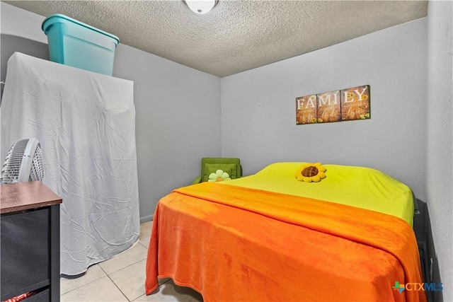 tiled bedroom featuring a textured ceiling