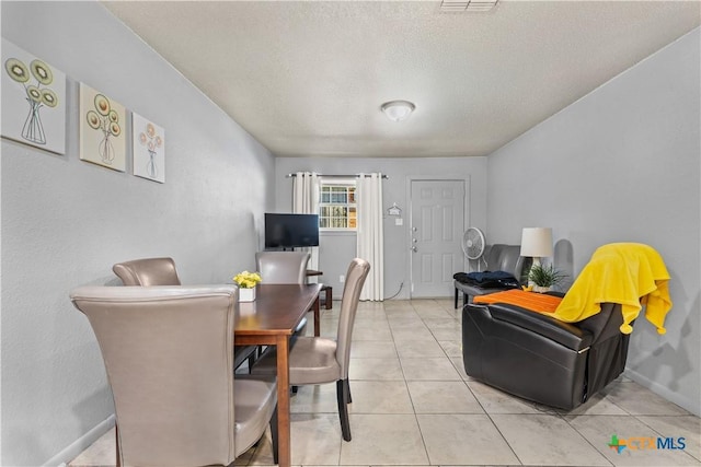 dining room with light tile patterned floors and a textured ceiling