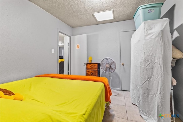 bedroom featuring light tile patterned floors and a textured ceiling