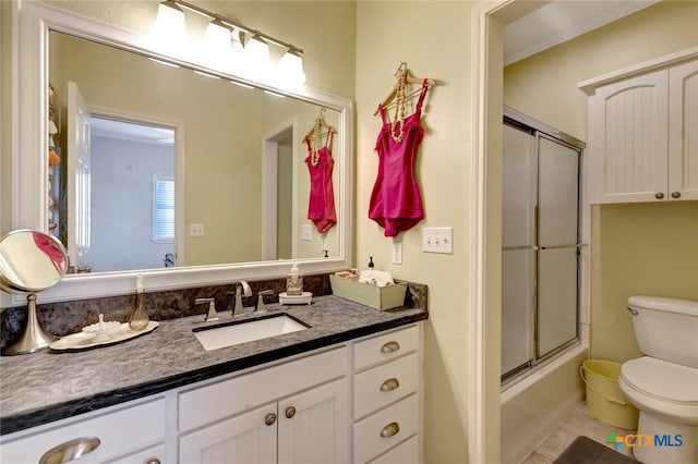 full bathroom featuring bath / shower combo with glass door, vanity, tile patterned floors, and toilet