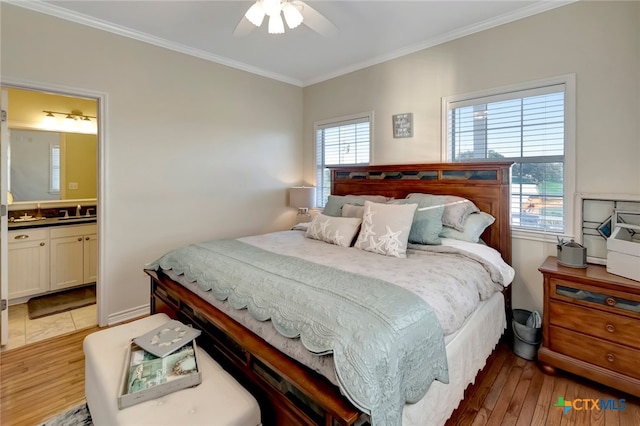 bedroom featuring hardwood / wood-style floors, multiple windows, ceiling fan, and connected bathroom