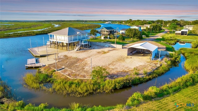 aerial view at dusk featuring a water view