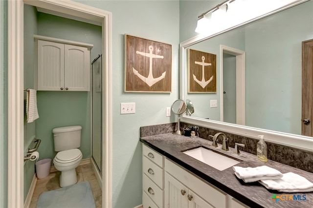 bathroom featuring a shower with door, vanity, toilet, and tile patterned flooring