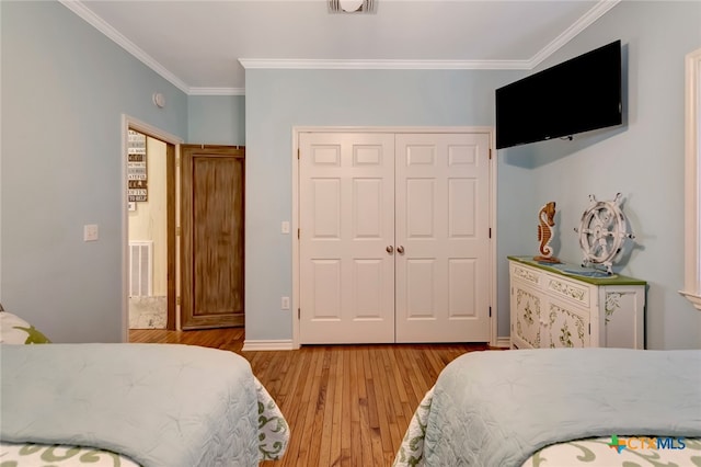 bedroom with light hardwood / wood-style floors, a closet, and ornamental molding