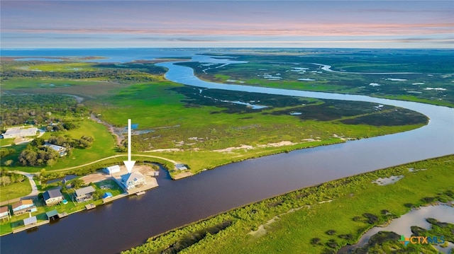 aerial view at dusk featuring a water view