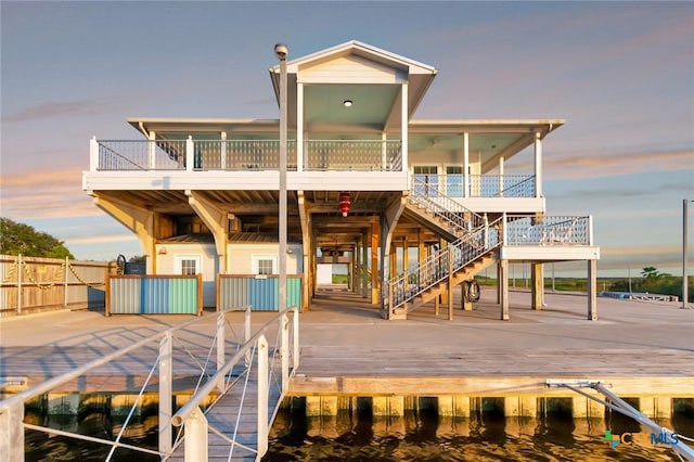 back house at dusk featuring a balcony