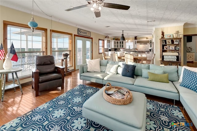 living room with hardwood / wood-style floors, ceiling fan, a textured ceiling, and french doors