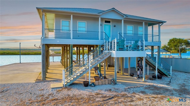 coastal home with a porch and a water view