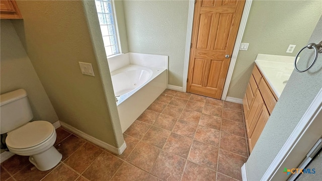 bathroom with tile patterned flooring, vanity, a bathing tub, and toilet