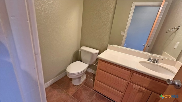 bathroom featuring tile patterned flooring, vanity, and toilet