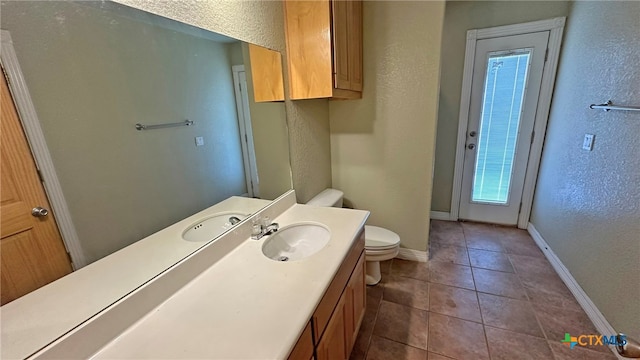 bathroom featuring vanity, tile patterned floors, and toilet