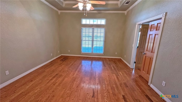 unfurnished room with ornamental molding, light hardwood / wood-style floors, ceiling fan, and a raised ceiling