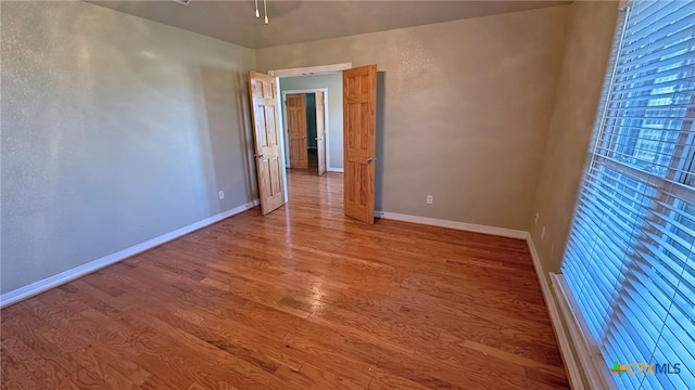 empty room with hardwood / wood-style flooring and ceiling fan