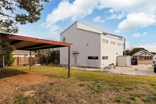 back of property with a lawn and a storage unit