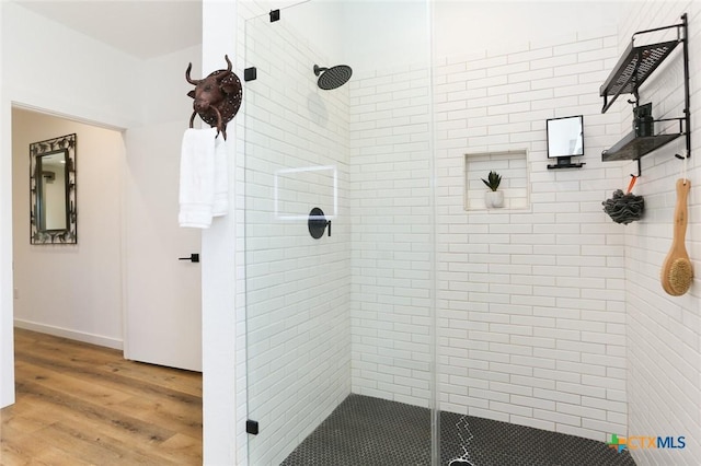 bathroom featuring a shower with shower door and wood-type flooring