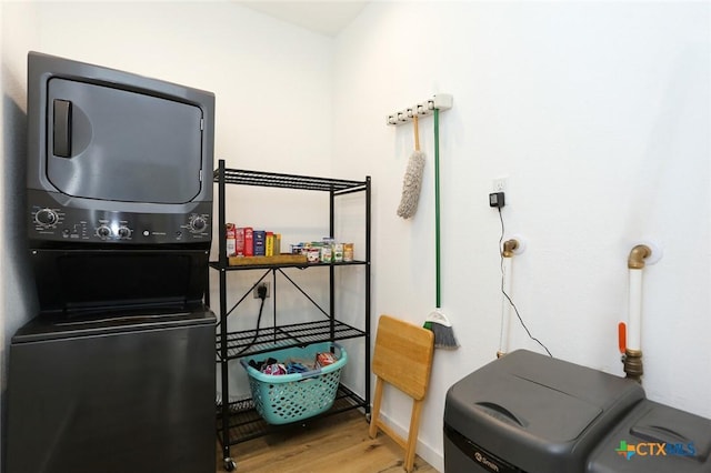 interior space with stacked washer / dryer and hardwood / wood-style flooring