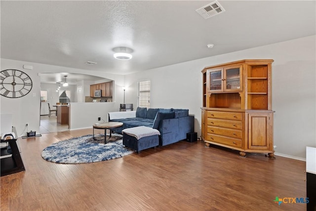 living room with ceiling fan and dark hardwood / wood-style flooring