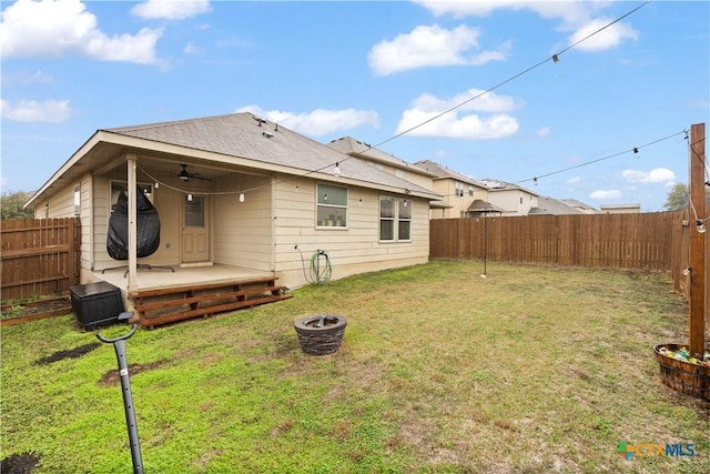 rear view of house featuring a wooden deck, ceiling fan, and a lawn