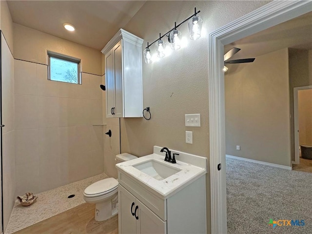 bathroom featuring vanity, toilet, and tiled shower