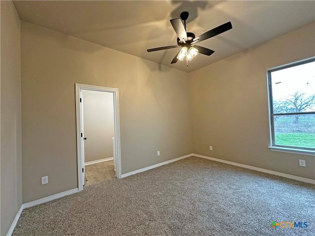 carpeted spare room featuring ceiling fan